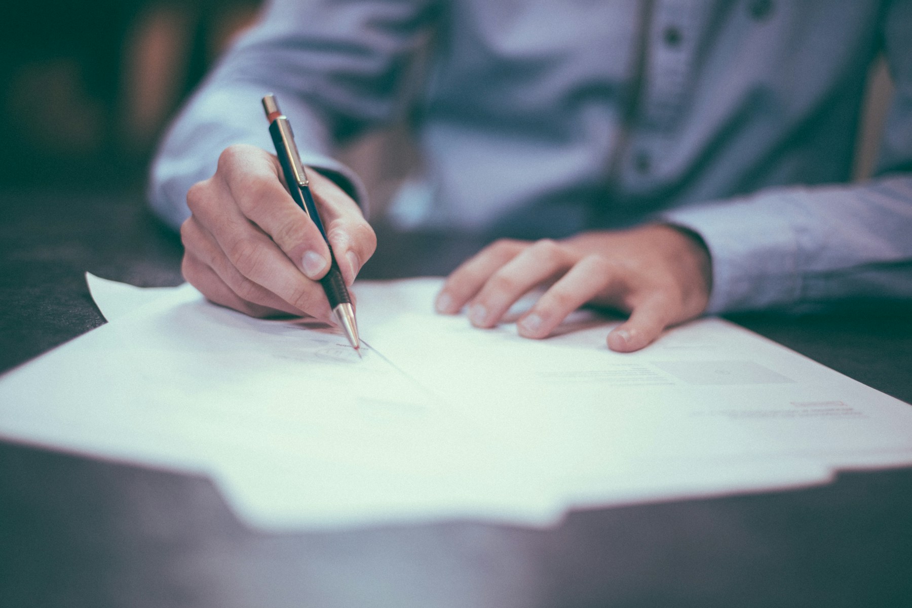 A client signing documents at an office desk